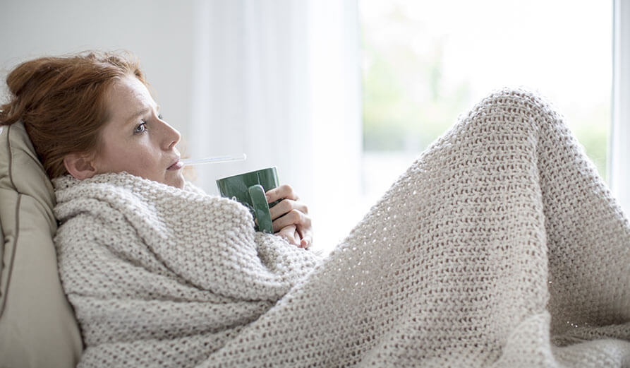 Frau misst Fieber Frau mit Fieberthermometer im Mund
