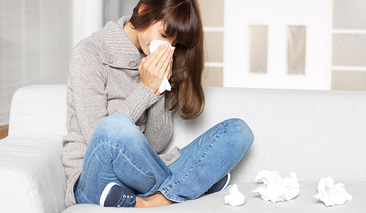 Frau mit Schnupfen Frau mit Schnupfen schnäuzt sich